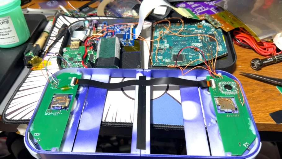 Interior do PlayStation 2 DUO durante a montagem, com placas, fios e estrutura roxa