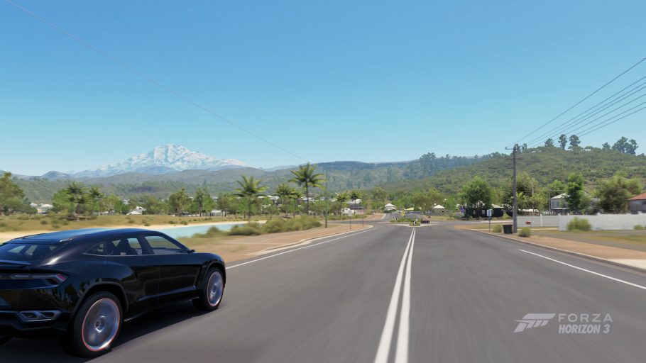 Carro percorrendo uma estrada rural em Forza Horizon 3 diante de uma paisagem montanhosa