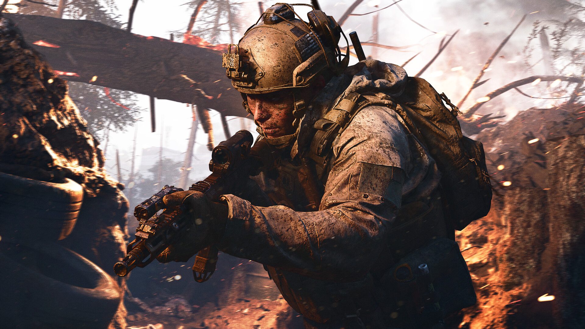 A heavily armed soldier in dusty combat gear crouches with a rifle in a war-torn forest, surrounded by charred trees, smoke, flying embers, and fiery orange light.